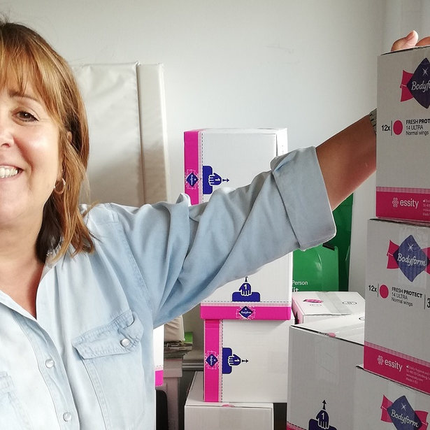 Woman in front of boxes of Bodyform sanitary products